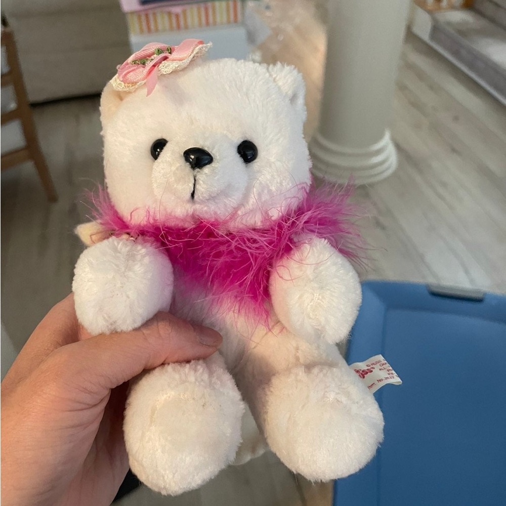 White stuffed toy best with pink boa